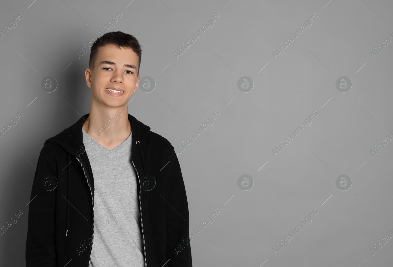 Photo of Portrait of teenage boy on grey background, space for text