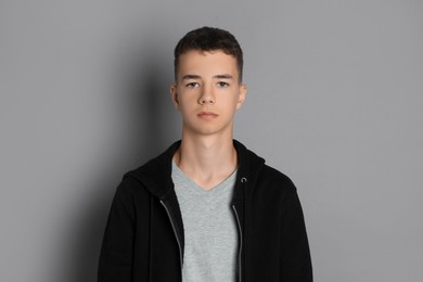 Photo of Portrait of teenage boy on grey background