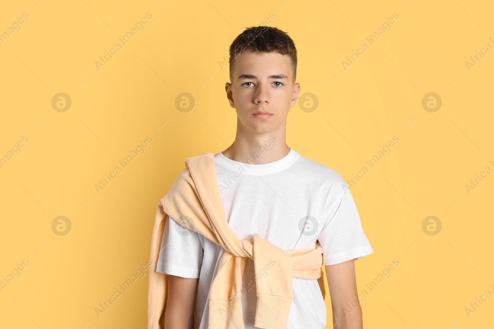 Photo of Portrait of teenage boy on yellow background