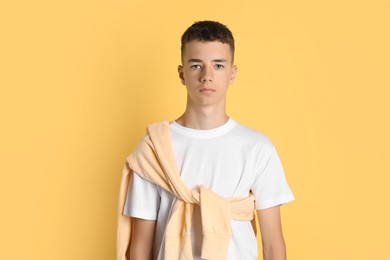 Portrait of teenage boy on yellow background