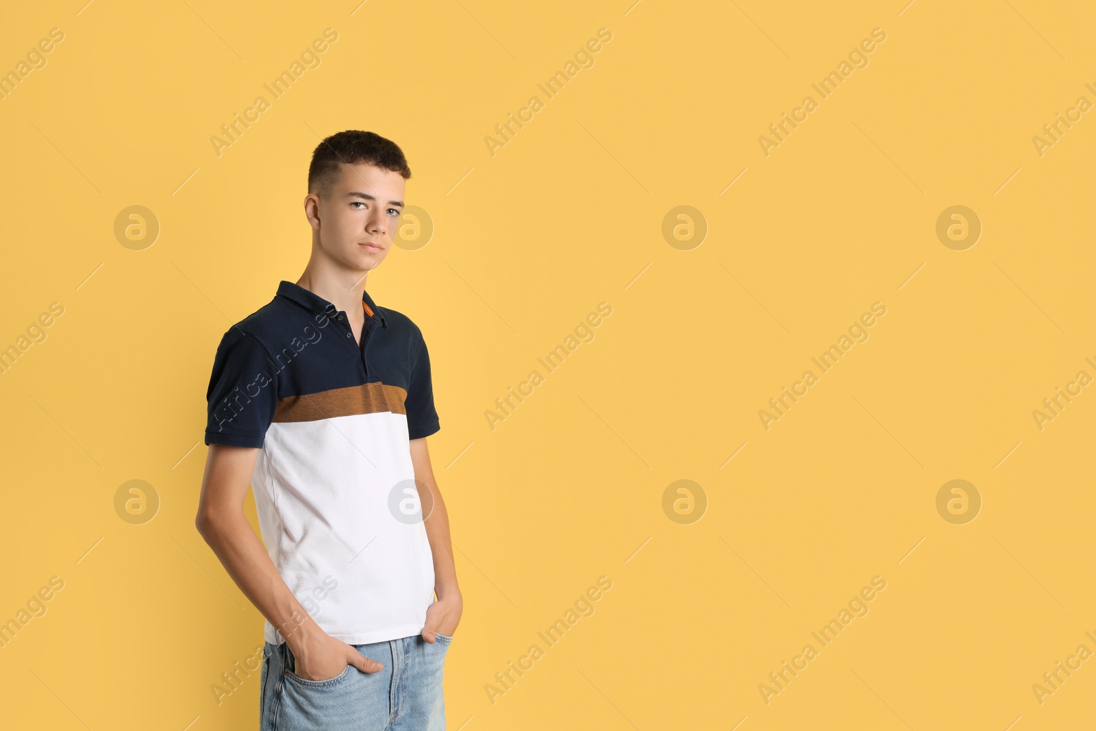 Photo of Portrait of teenage boy on yellow background, space for text