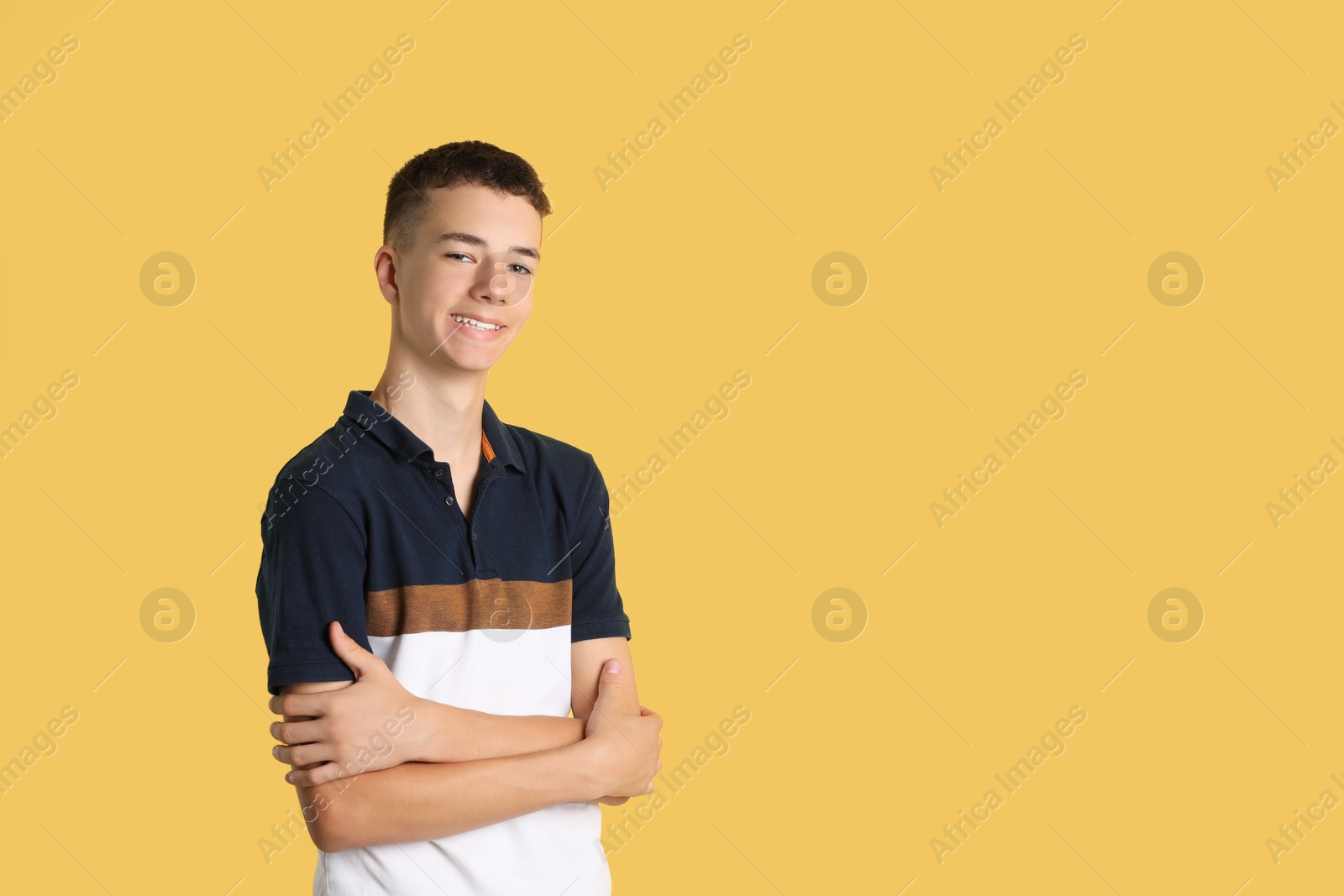 Photo of Portrait of teenage boy on yellow background, space for text