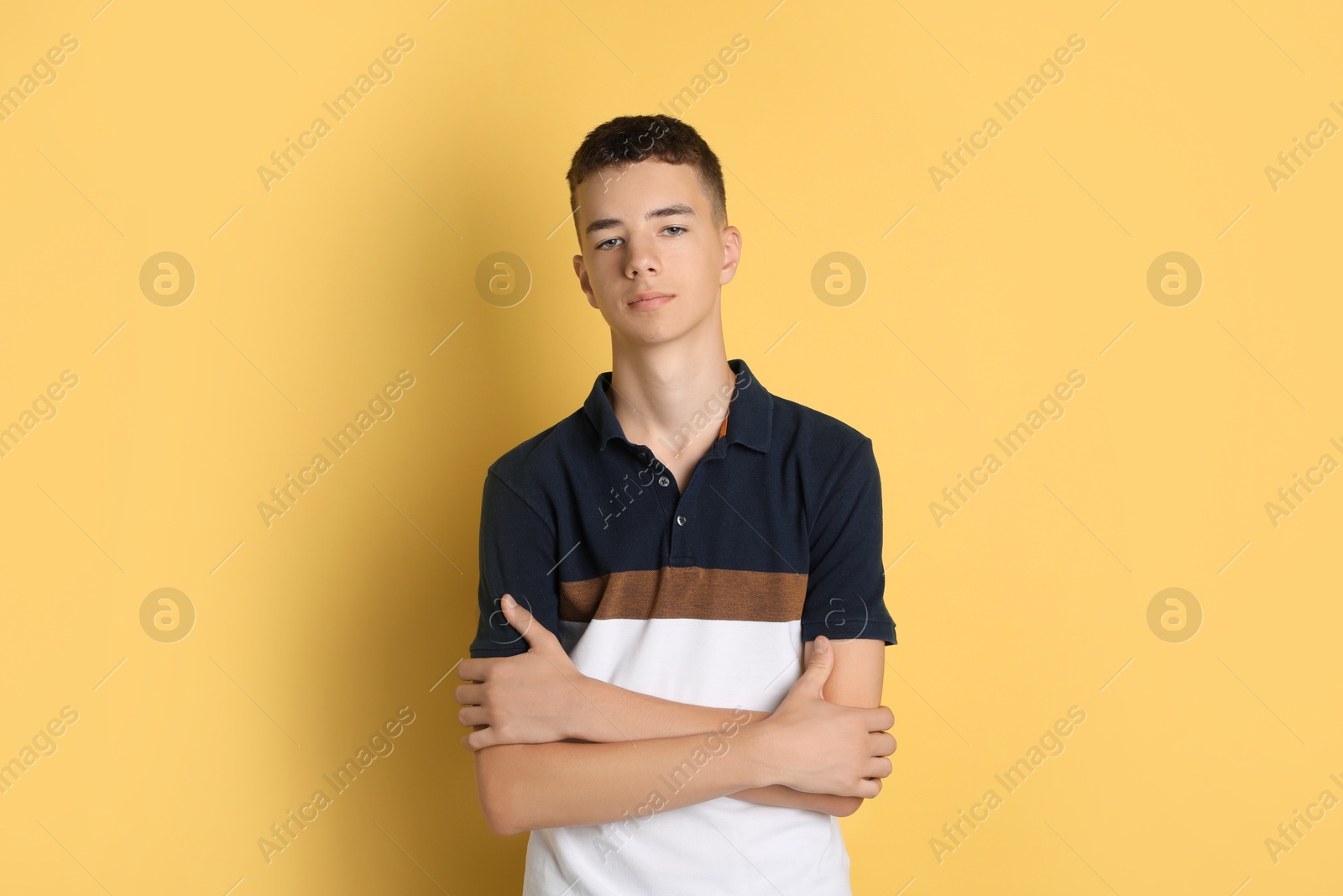 Photo of Portrait of teenage boy on yellow background