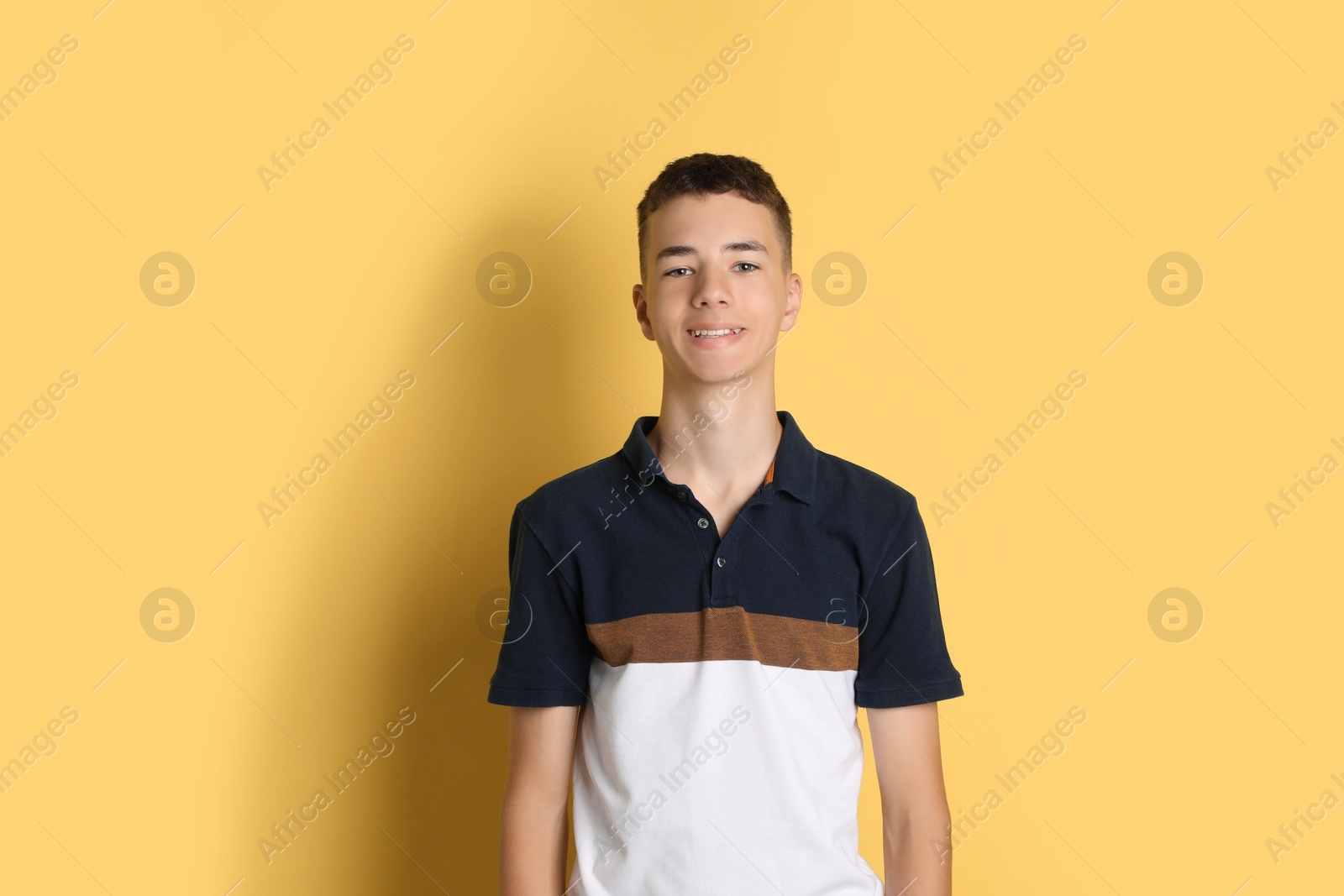 Photo of Portrait of teenage boy on yellow background