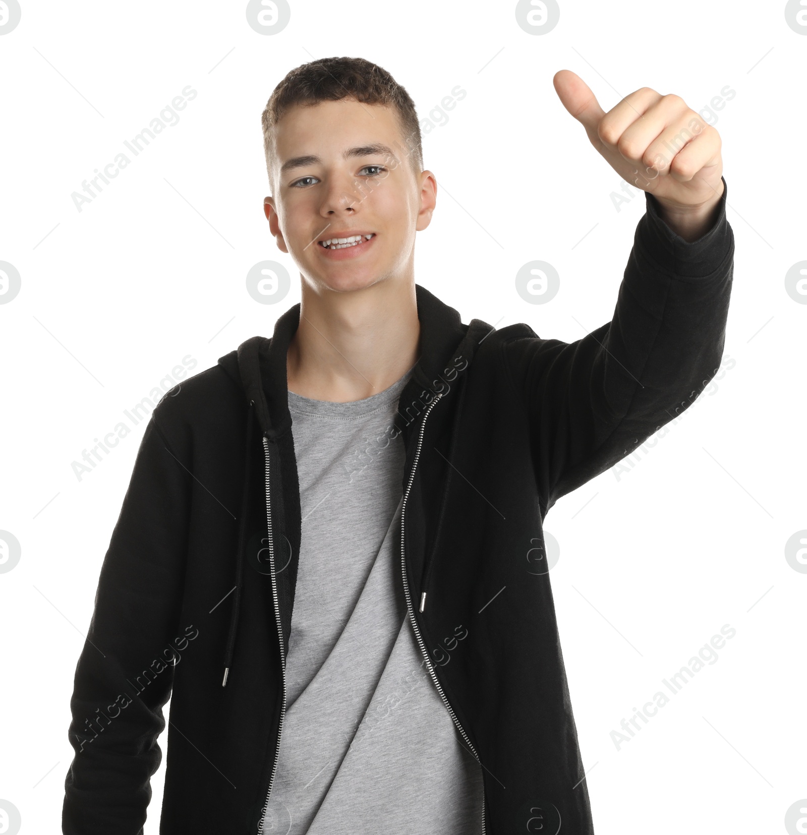 Photo of Portrait of teenage boy showing thumbs up on white background