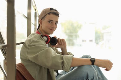 Portrait of teenage boy near railings on blurred background