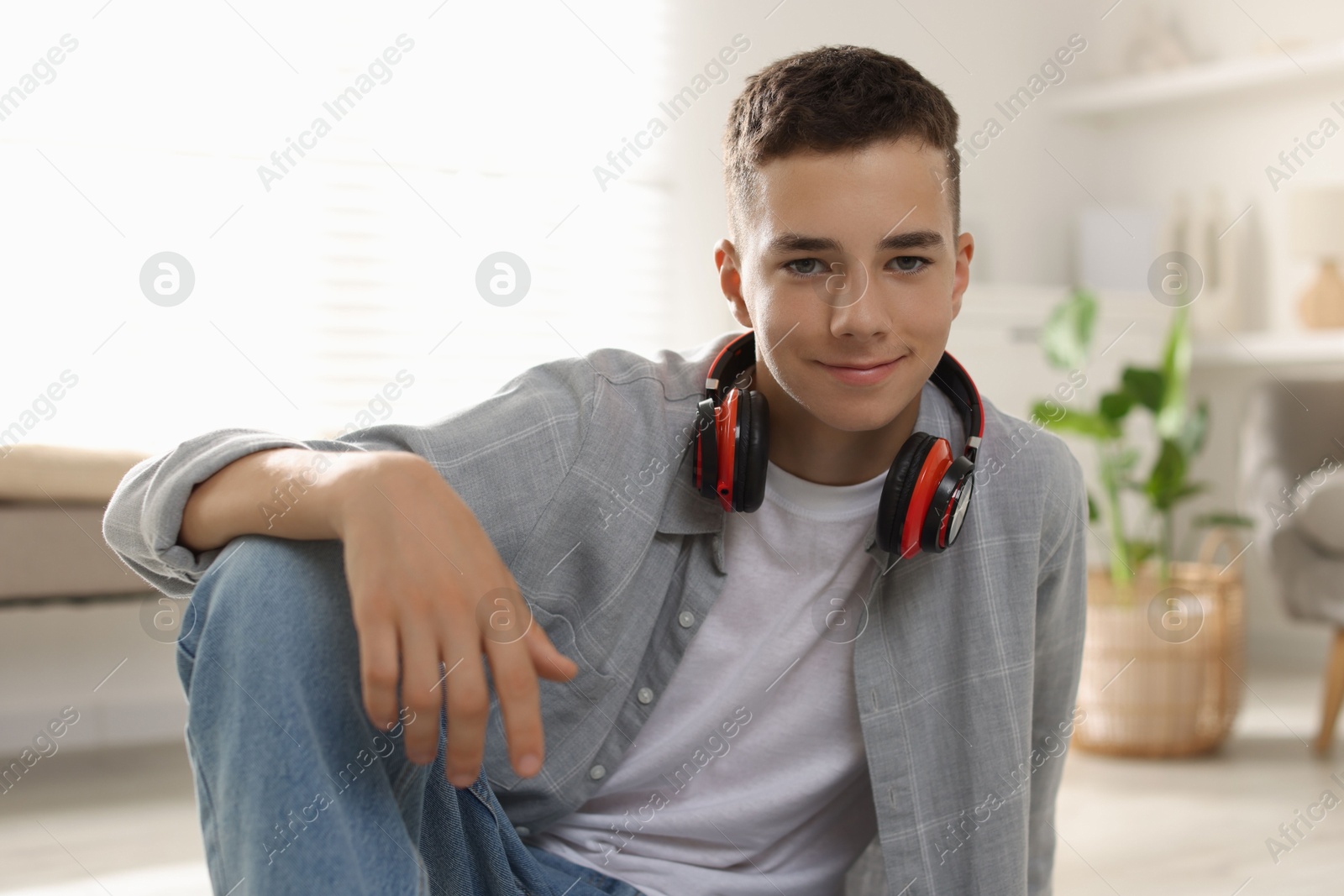 Photo of Portrait of teenage boy with headphones at home