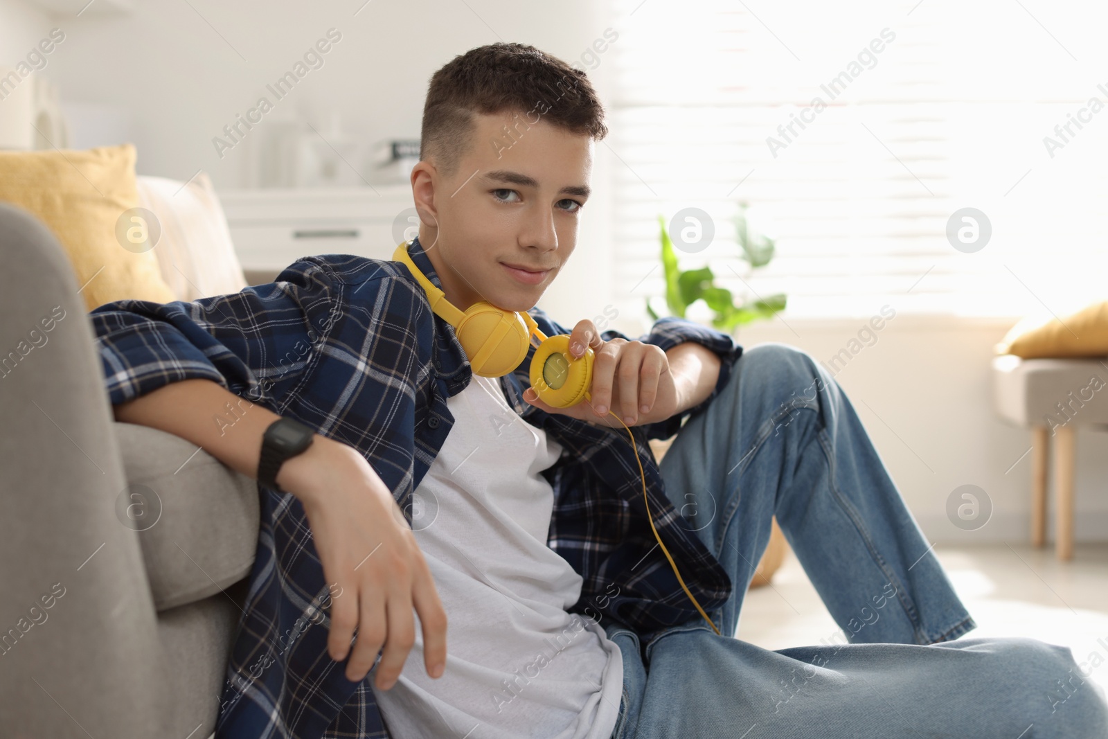 Photo of Portrait of teenage boy with headphones at home