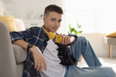 Portrait of teenage boy with headphones at home