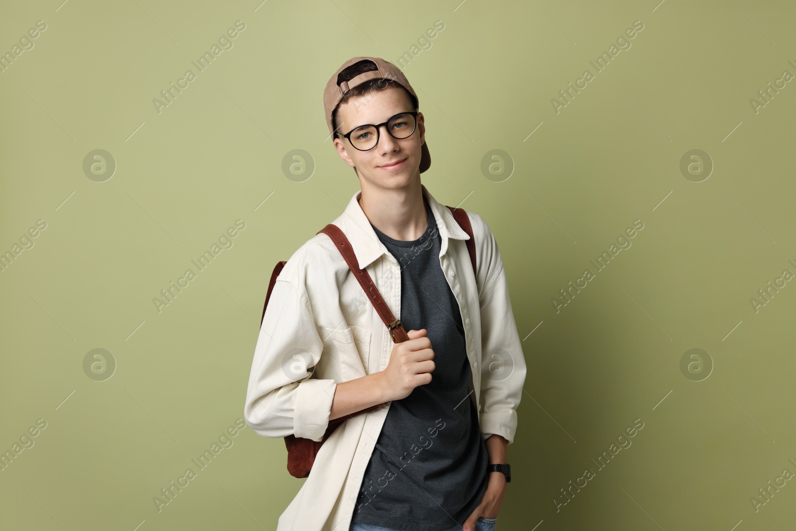 Photo of Portrait of teenage boy with backpack on green background