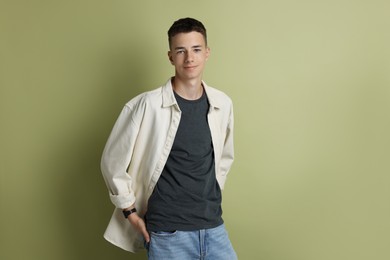 Portrait of teenage boy on green background