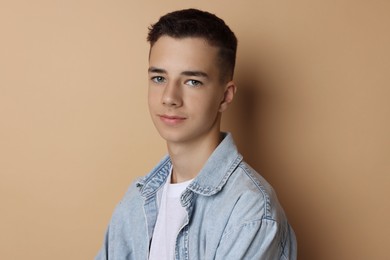 Photo of Portrait of teenage boy on dark beige background