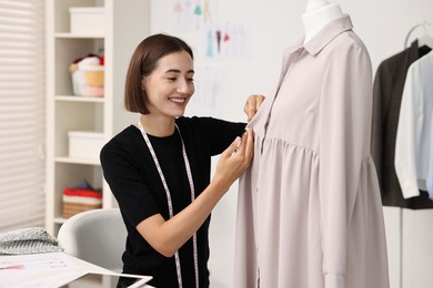 Photo of Fashion designer with needles working in workshop