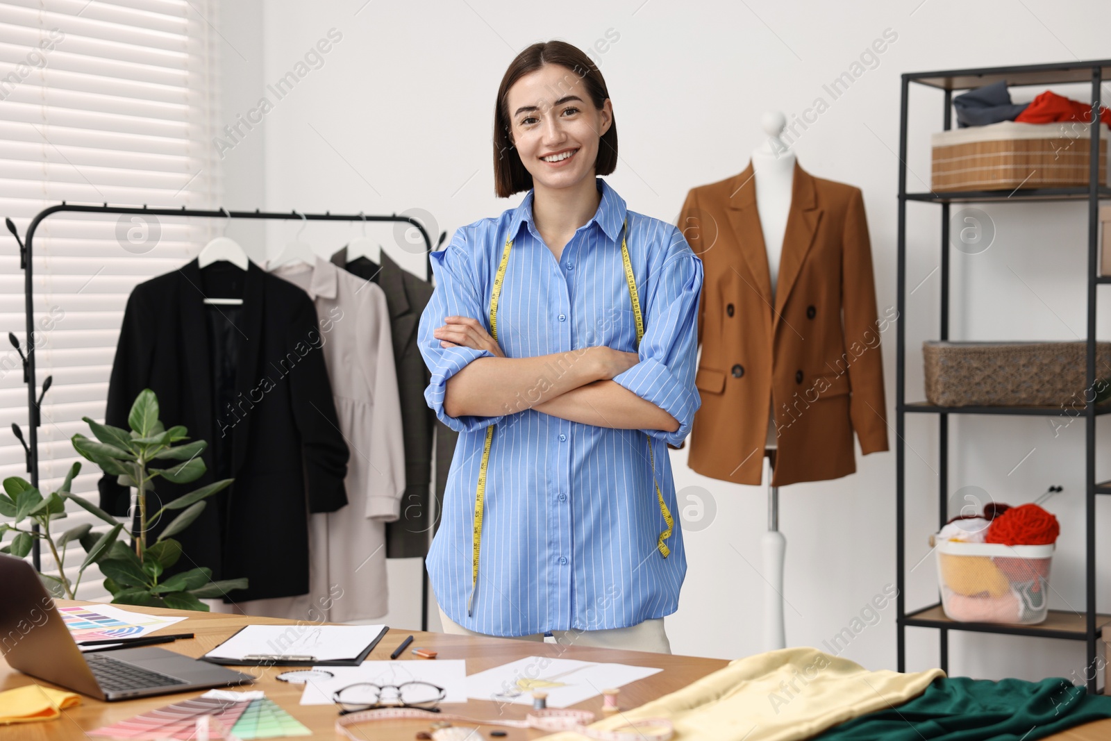 Photo of Fashion designer with measuring tape in workshop