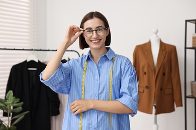 Fashion designer with measuring tape in workshop