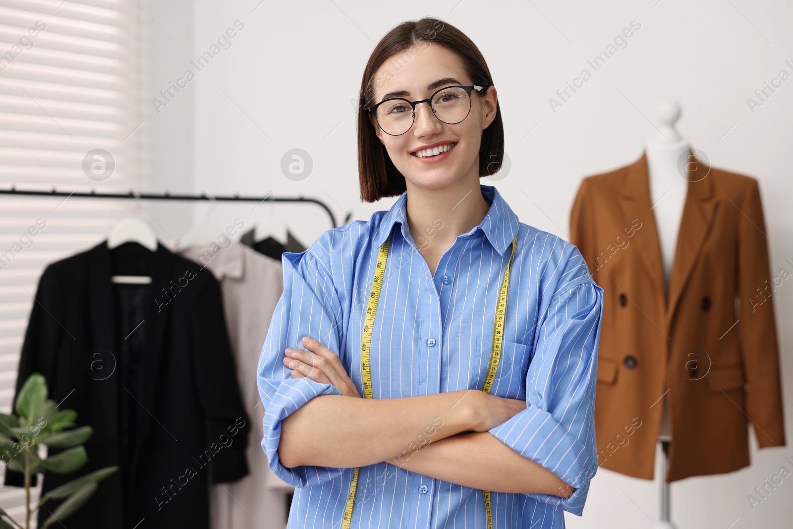 Photo of Fashion designer with measuring tape in workshop