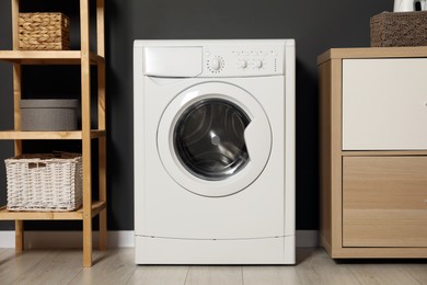 Photo of Washing machine, wooden rack and storage cabinet indoors