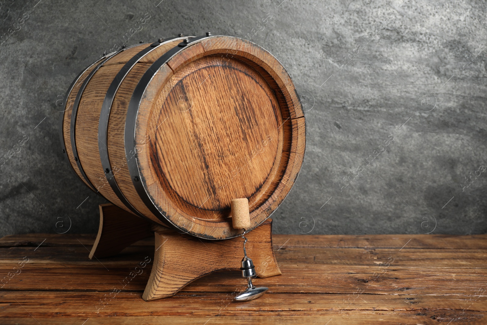 Photo of Corkscrew with metal handle, cork and wooden barrel on table, space for text