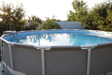 Photo of Above ground swimming pool in garden on sunny day