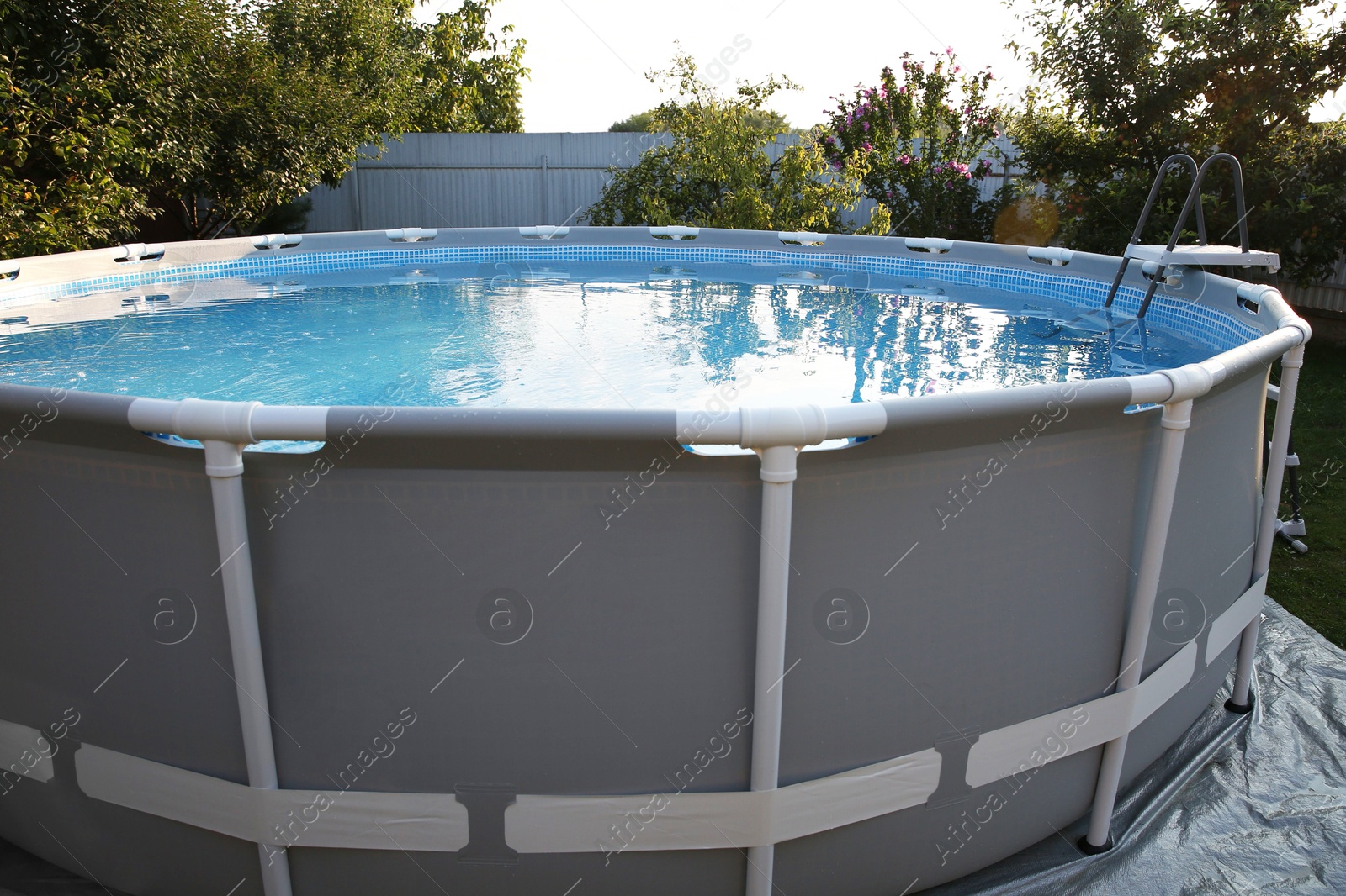 Photo of Above ground swimming pool in garden on sunny day