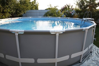 Photo of Above ground swimming pool in garden on sunny day