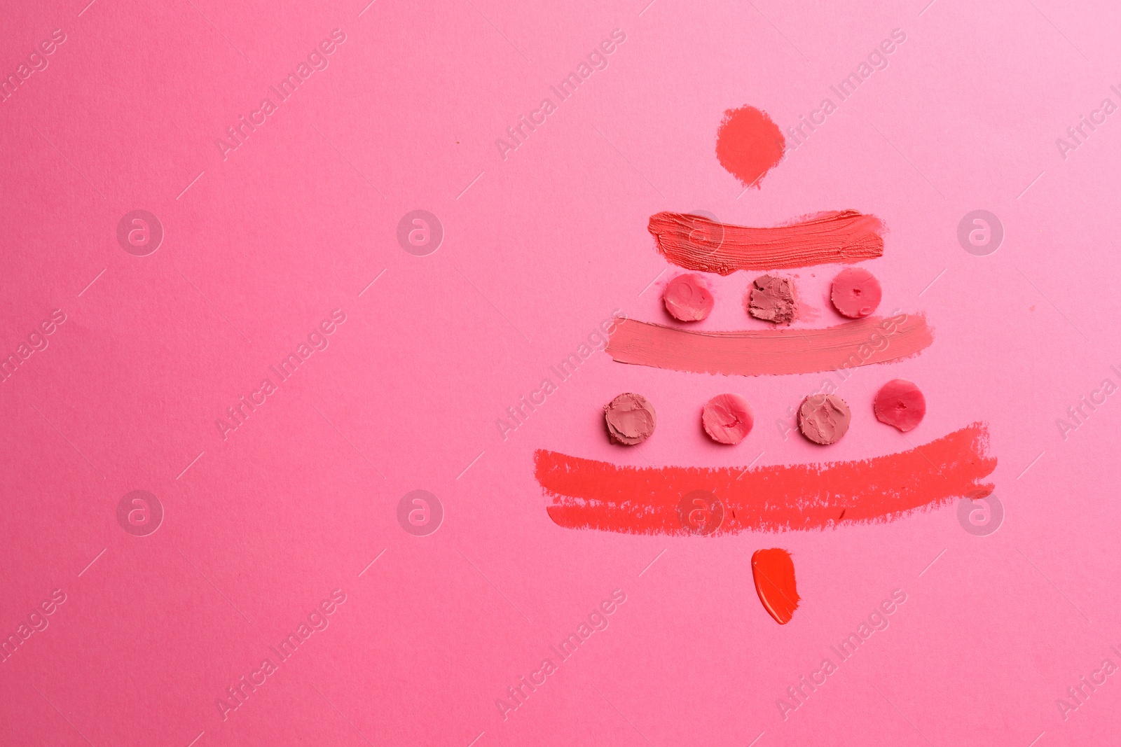 Photo of Christmas tree drawn with lipsticks on pink background, top view. Space for text