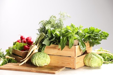 Photo of Different fresh herbs, cabbages and radishes on white table