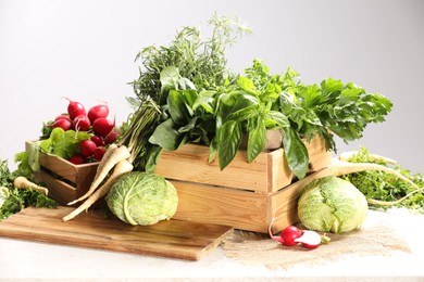 Photo of Different fresh herbs, cabbages and radishes on white table