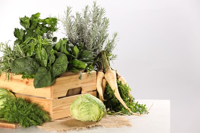 Different fresh herbs and cabbage on white table. Space for text