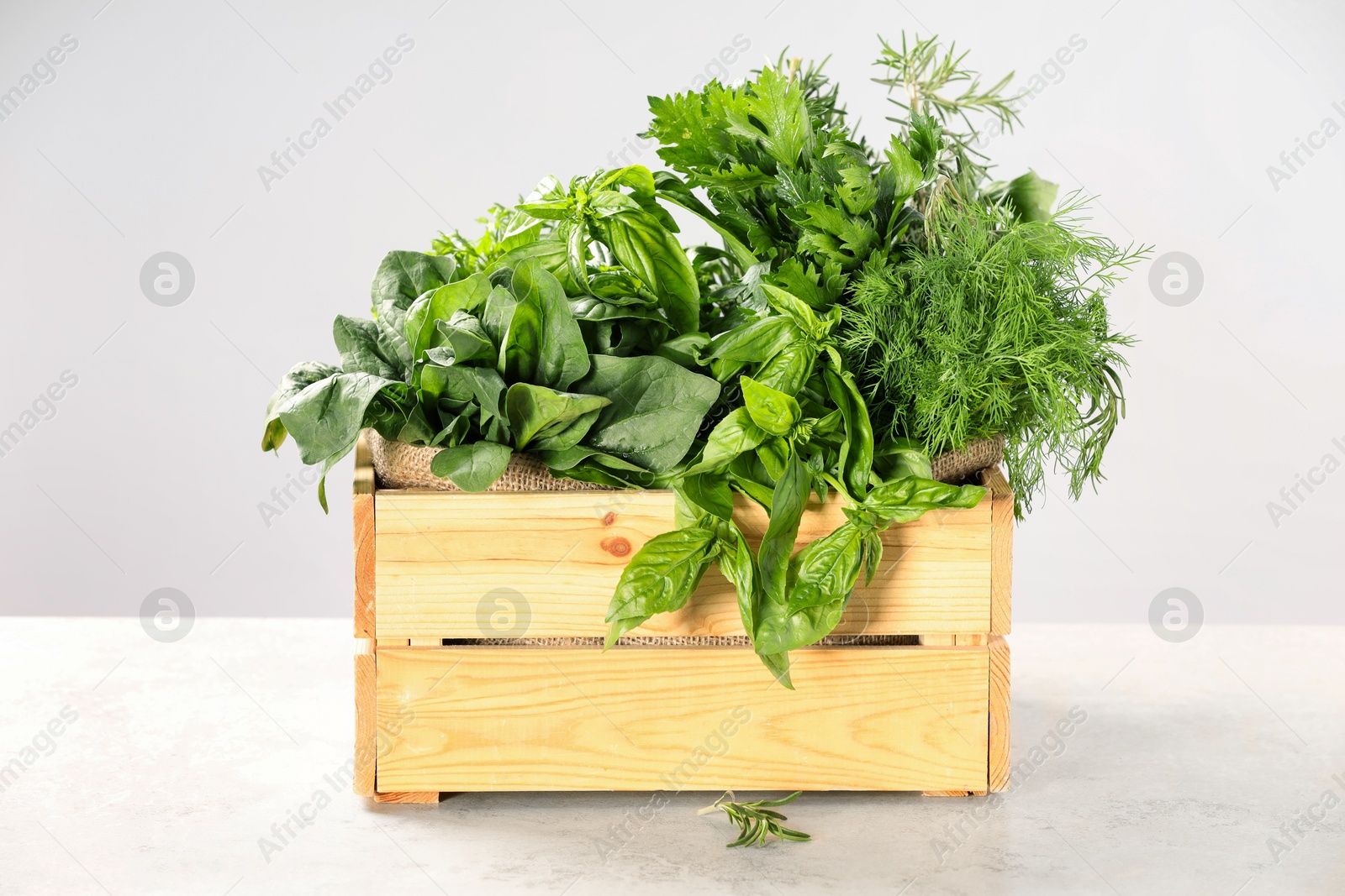 Photo of Different fresh herbs in wooden basket on white table