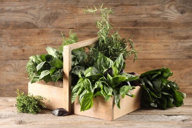 Different fresh herbs in basket on wooden table