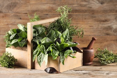 Photo of Different fresh herbs in basket on wooden table