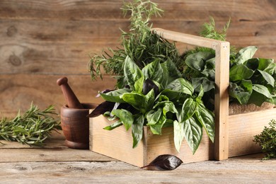 Photo of Different fresh herbs in basket on wooden table