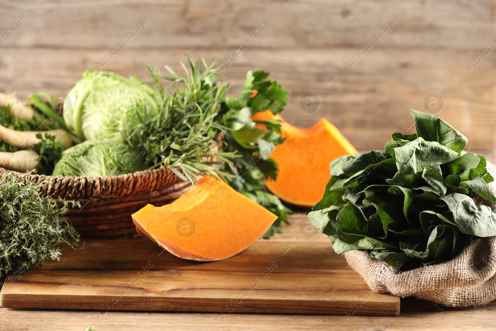 Photo of Different fresh herbs, cabbages and pumpkin on wooden table