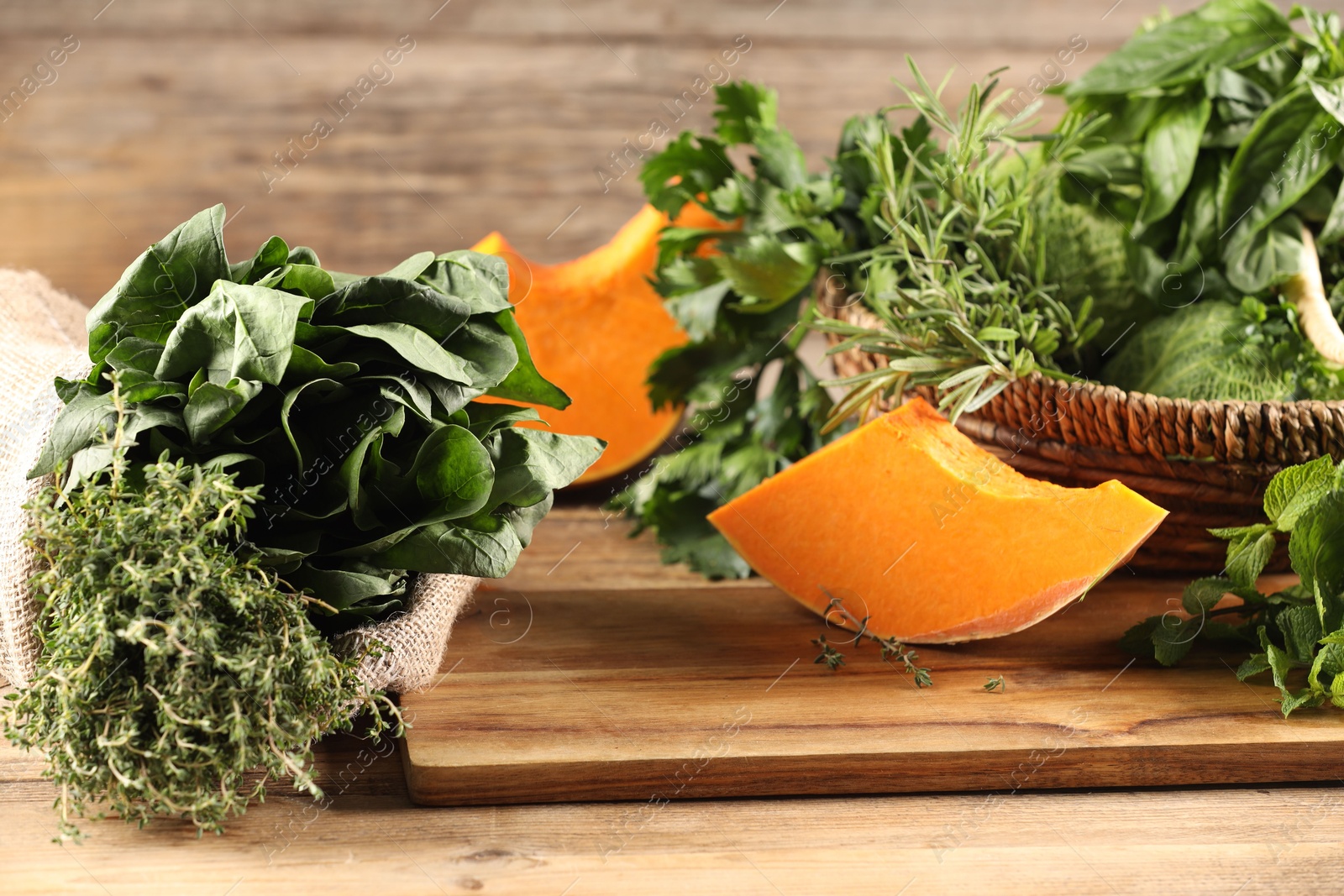 Photo of Different fresh herbs and pumpkin on wooden table