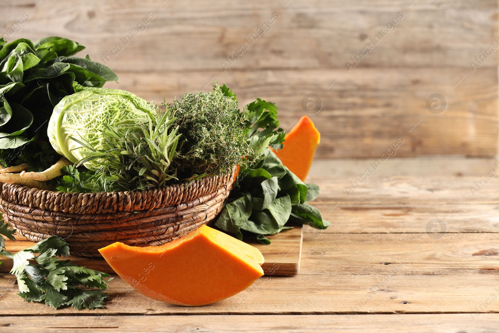 Photo of Different fresh herbs, cabbages and pumpkin on wooden table, space for text