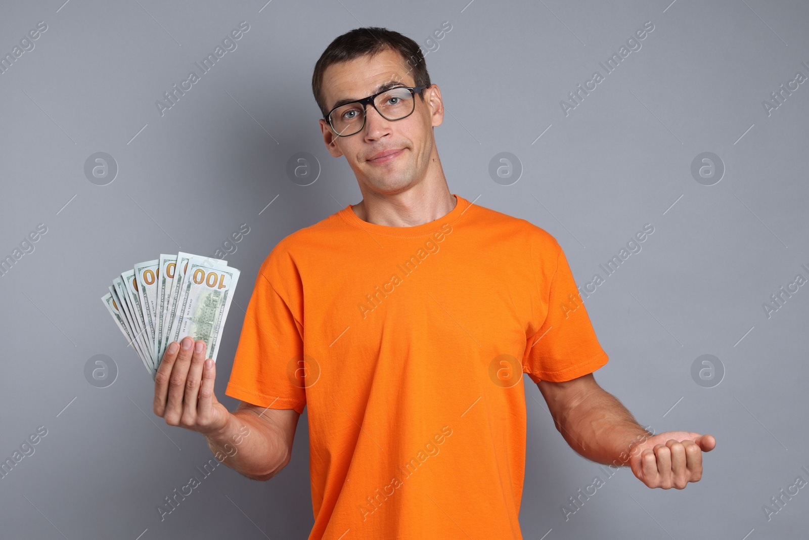 Photo of Man with dollar banknotes on grey background