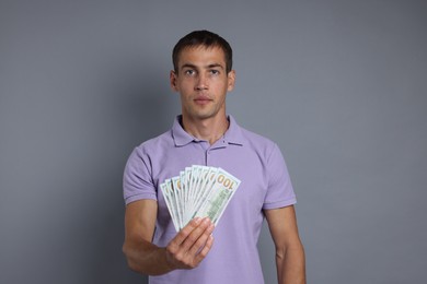 Photo of Man with dollar banknotes on grey background