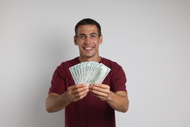 Photo of Happy man with money on white background