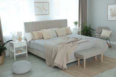 Photo of Big comfortable bed in room. Interior design