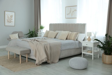 Photo of Big comfortable bed in room. Interior design