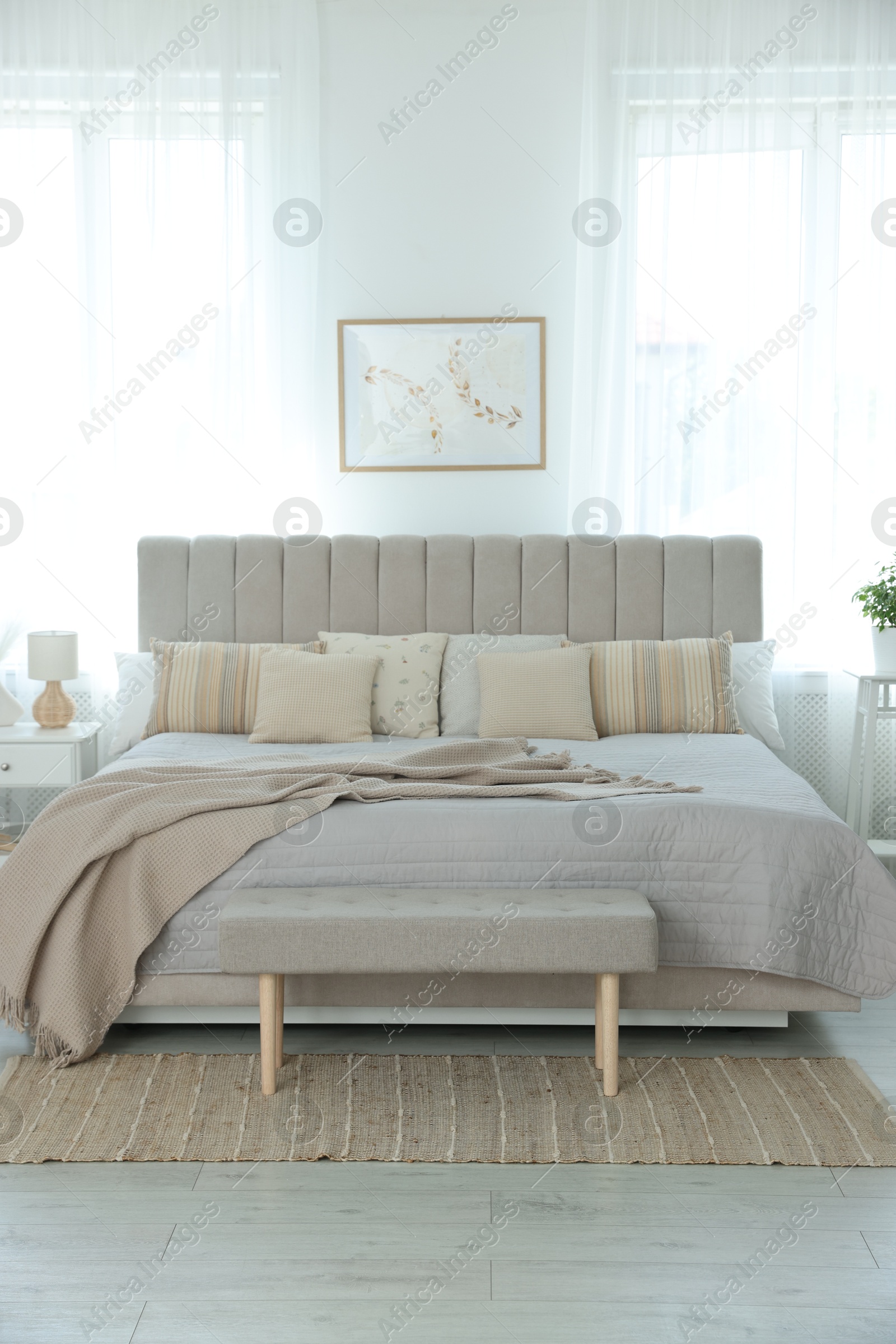 Photo of Big comfortable bed in room. Interior design