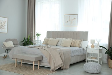 Photo of Big comfortable bed in room. Interior design