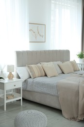 Photo of Big comfortable bed in room. Interior design