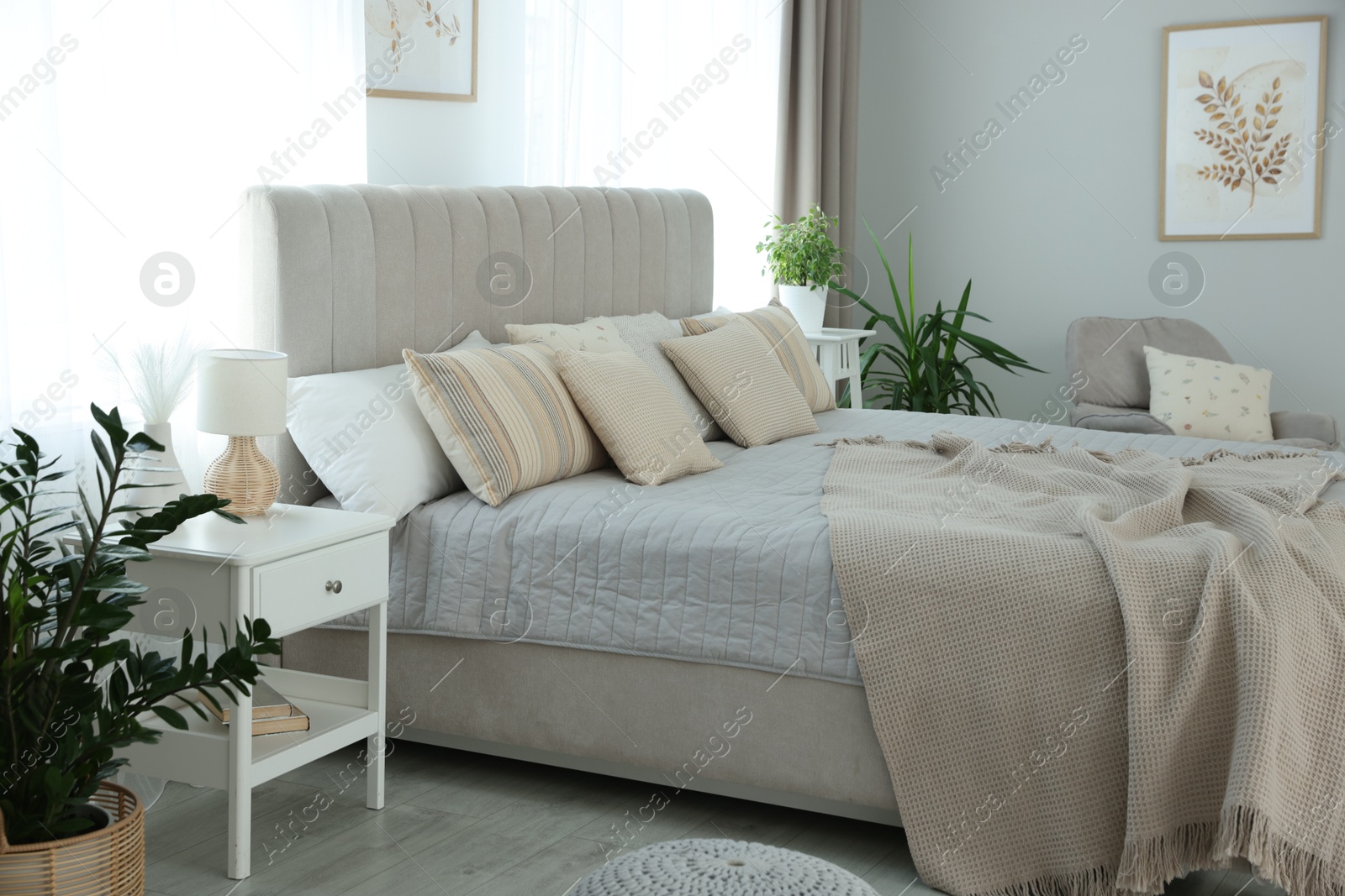 Photo of Big comfortable bed in room. Interior design