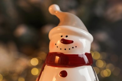 Photo of Funny snowman figure against blurred lights, closeup