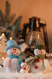 Photo of Funny snowman figures on artificial snow against blurred background