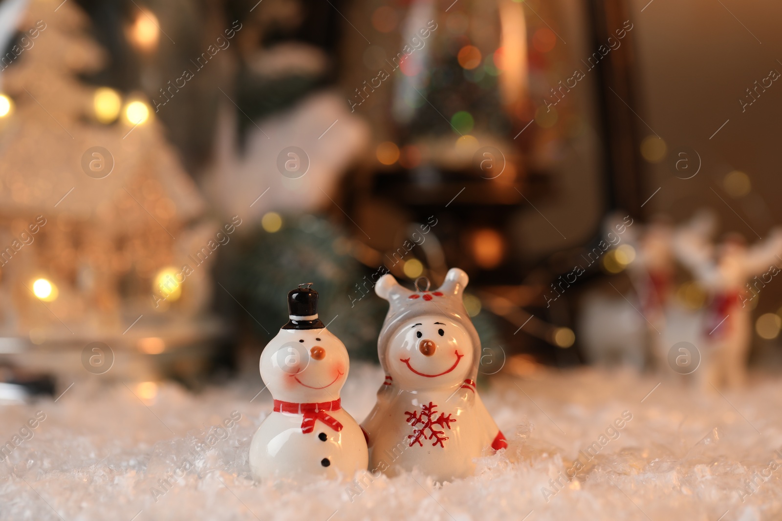 Photo of Funny snowman figures on artificial snow against blurred background