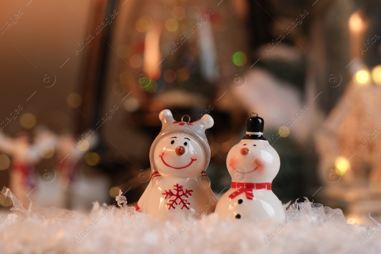 Photo of Funny snowman figures on artificial snow against blurred background