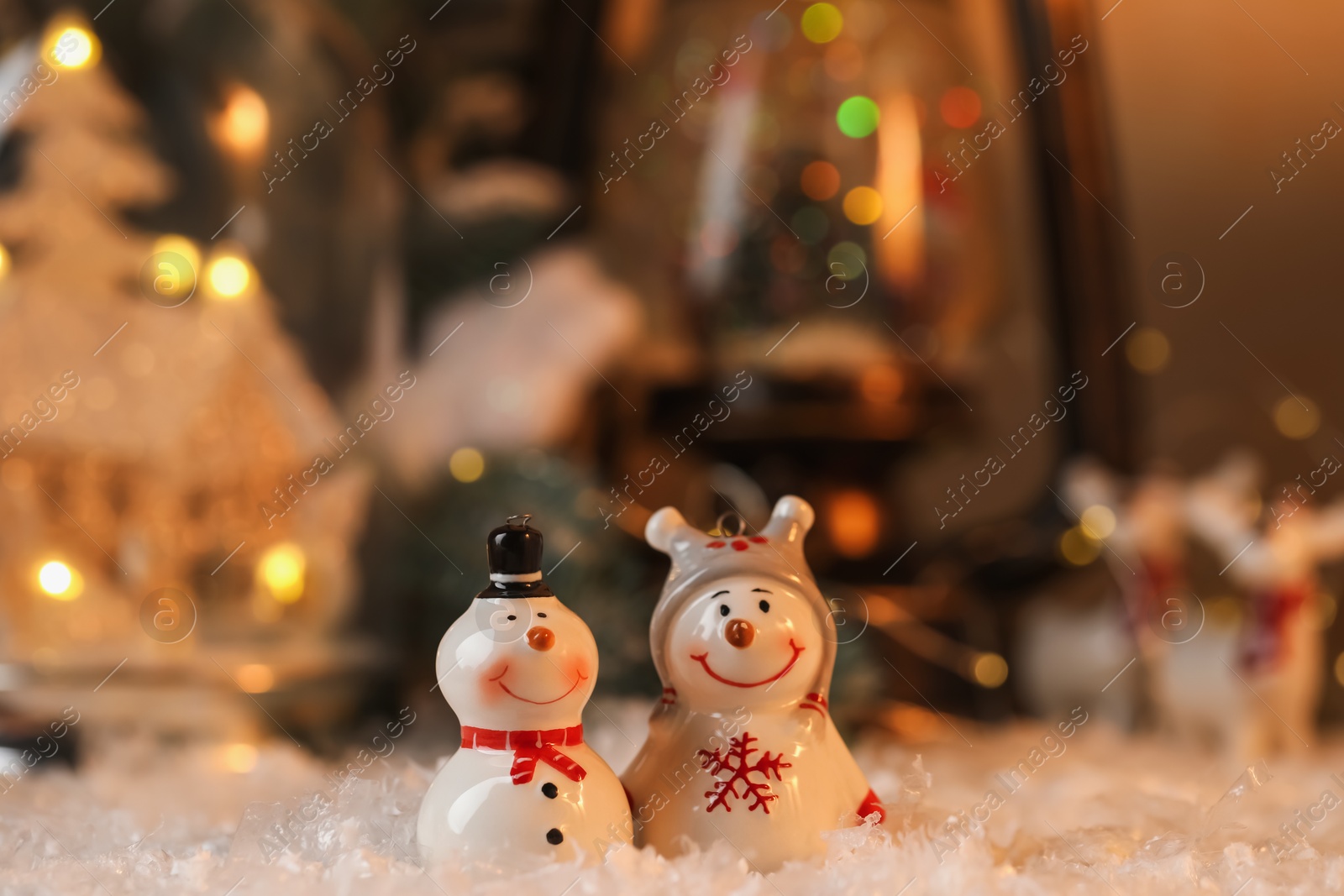 Photo of Funny snowman figures on artificial snow against blurred background